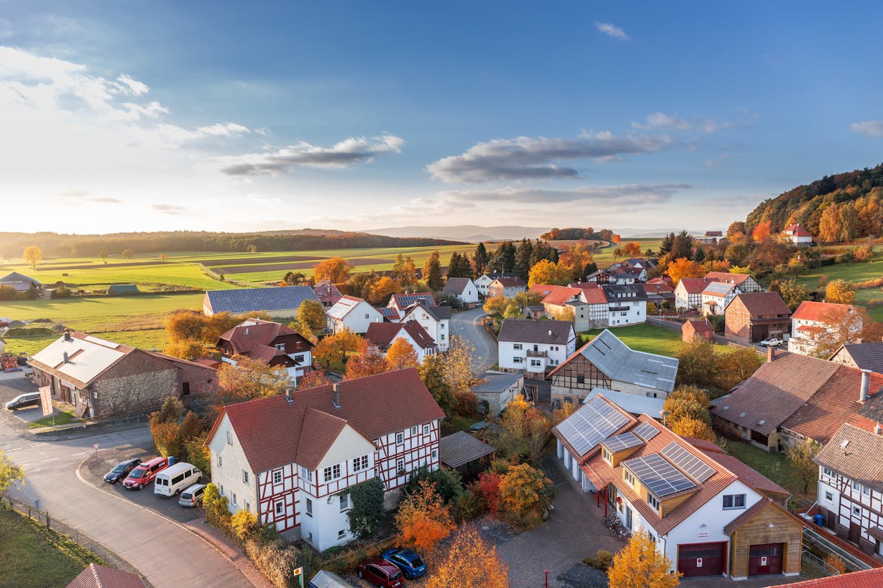 our-services-3 Charming aerial view of a rural village in autumn with vivid colors and clear skies.