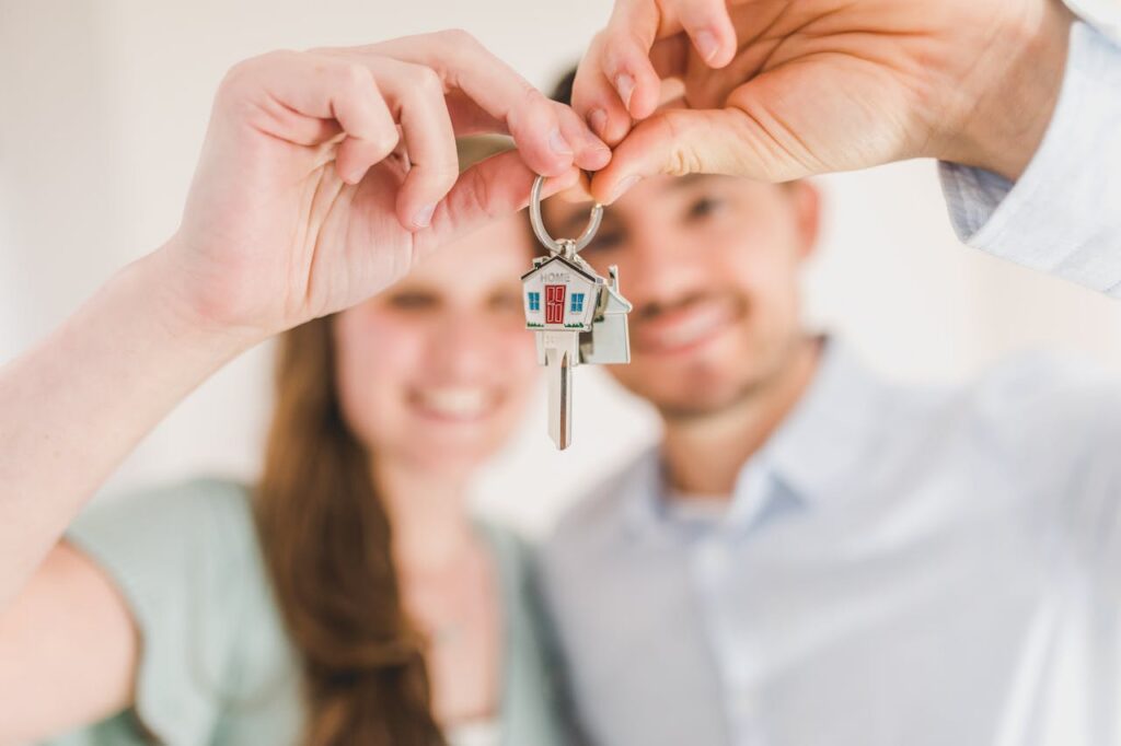 pexels photo 8293700 Young couple holding keys to their new home, symbolizing a fresh start and investment in real estate.